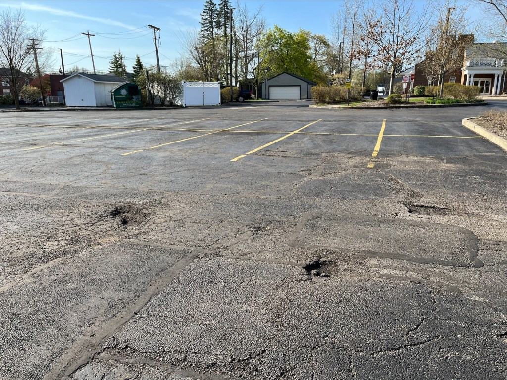 An early morning snapshot of three potholes in the parking lot
