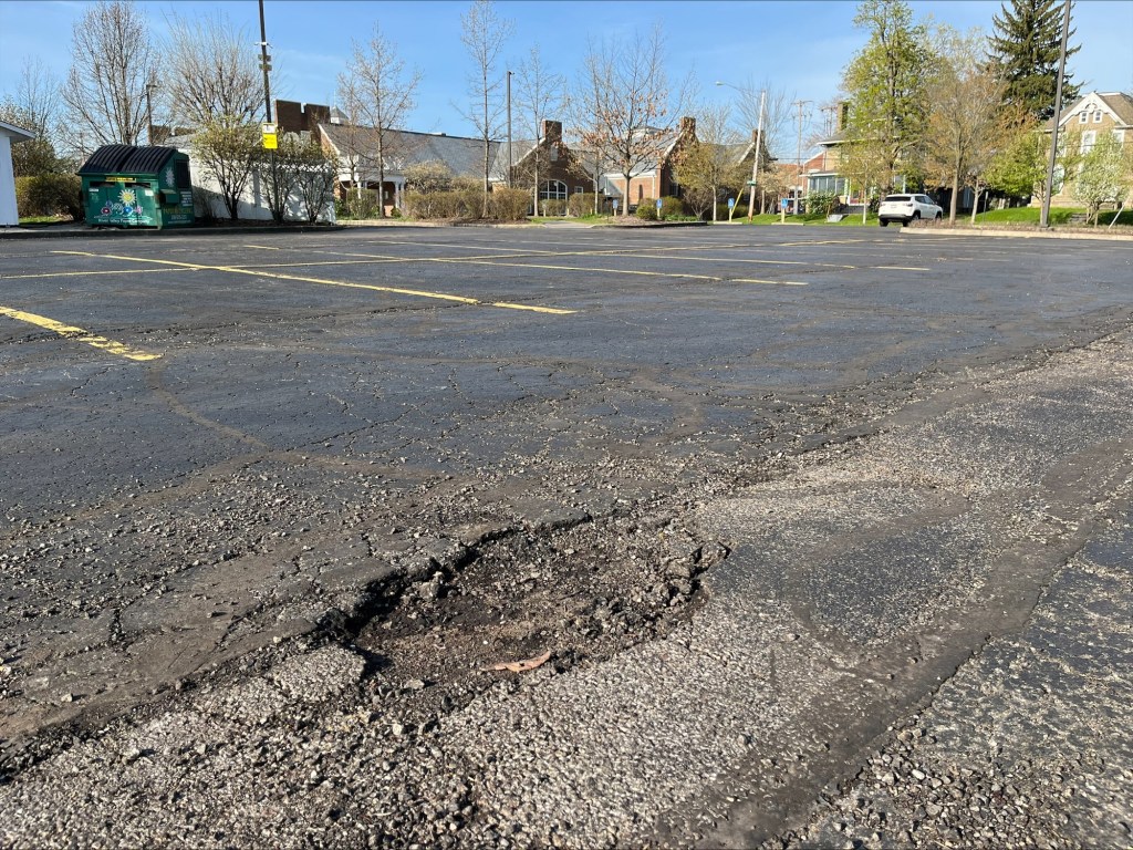 A third morning snapshot of a pothole in the parking lot