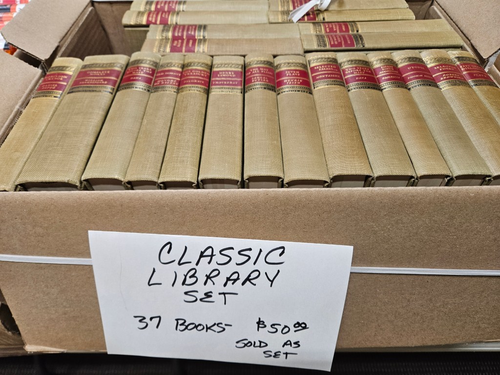cardboard box filled with man identical books, spine up. Tag on front reads Classic Library Set 37 books