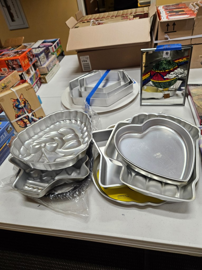 cake pans and books for sale displayed on a table