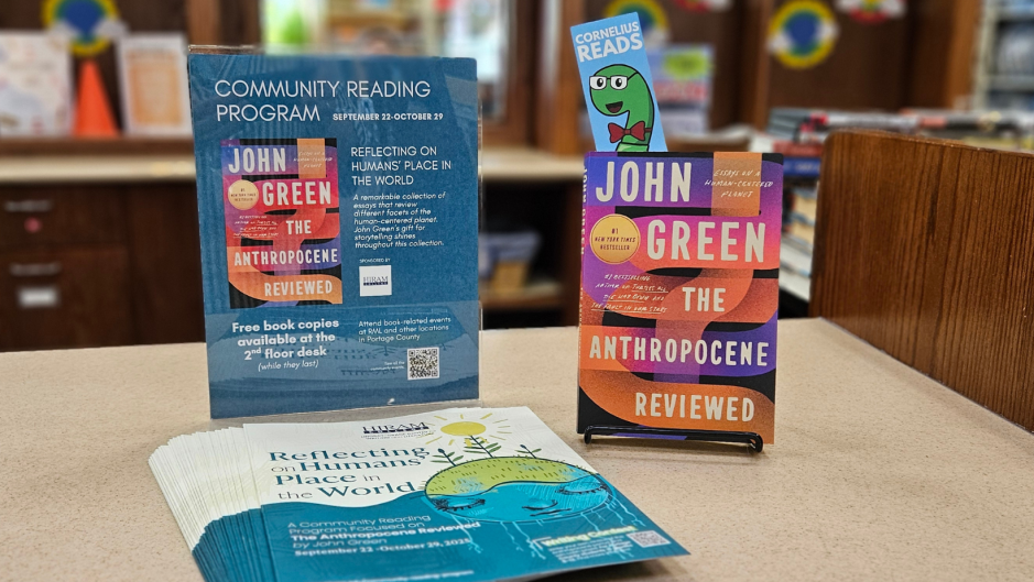 copy of the book, The Anthropocene Revealed, sitting on a countertop. A vertical flyer and brochures are nearby.