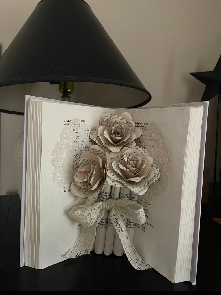 open book with pages folded and embellished with book page roses
